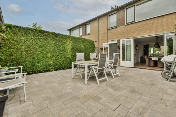 Neat powerful patio with sitting area and small garden near wooden fence